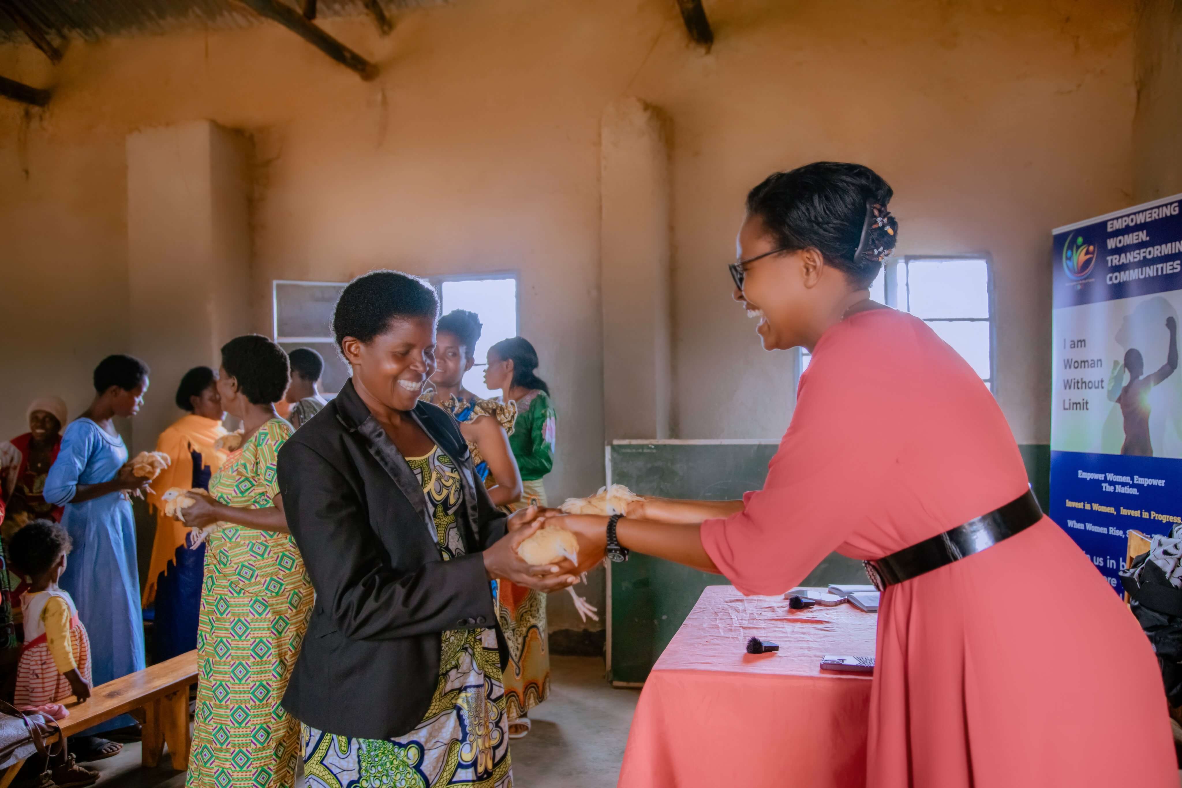 Women receiving chickens through the savings groups initiative